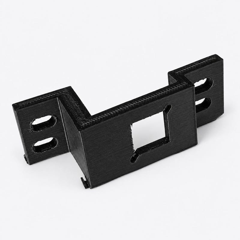 Black polycarbonate grille camera bracket with a camera opening and slotted mounting holes.